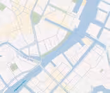 En digital karta som visar en flod som rinner genom en stad, med olika broar och gator märkta på danska. Området omfattar byggnader, parker och vattendrag som illustrerar en del av en stad med detaljplaneringslinjer.