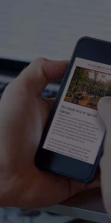 En person i en vit skjorta håller en smartphone som visar en onlineartikel om en trädgård i koreansk stil, medan en bärbar dator är öppen i bakgrunden. Artikeln har ett foto med text under.